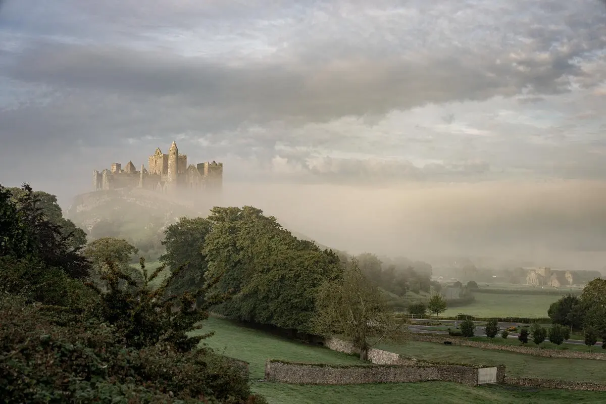 The Rock of Cashel on its limestone outcrop with early morning mist across the plain below